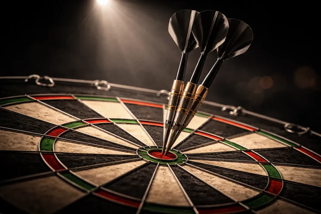 Dartpfeile stecken in der Triple-20 auf einem professionellen Dartboard unter Bühnenlicht
